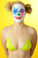 Clown in Bikini zur Karneval, Fasching oder Fastnacht ist bunt geschminkt und lacht
