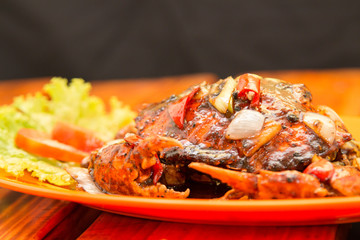 Crab cooked with black pepper sauce on plate with chili and onion