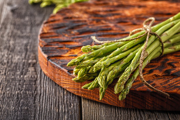 Fresh asparagus on the wooden background.