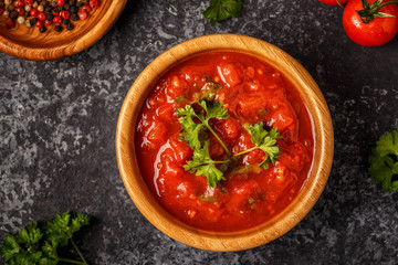 Tomato sauce with garlic and parsley in a wooden bowl.