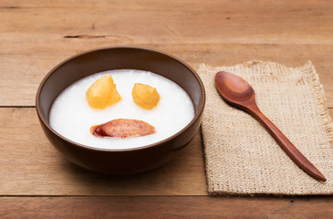 Traditional porridge rice gruel or congee in brown bowl
