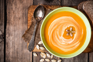 Pumpkin soup on rustic wooden background