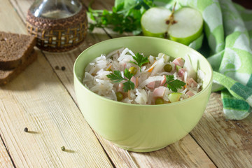 Salad with sauerkraut, ham, apple and green peas. Snack on a fes