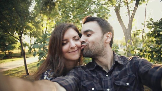 young couple in love take selfie in park