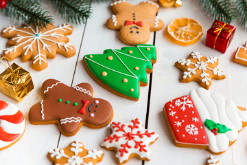 Christmas cookies with candy and  festive branches fir. Homemade delicious Christmas gingerbread cookies on the wooden background.