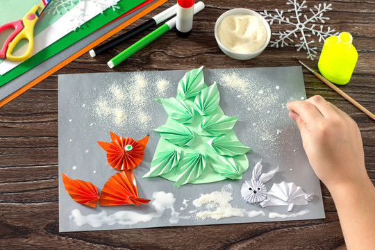 The child makes a paper Christmas tree, snow, fox and hare. Crea