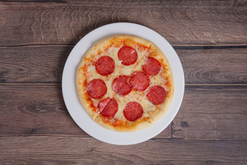 top point of view of pizza pepperoni on wooden plate