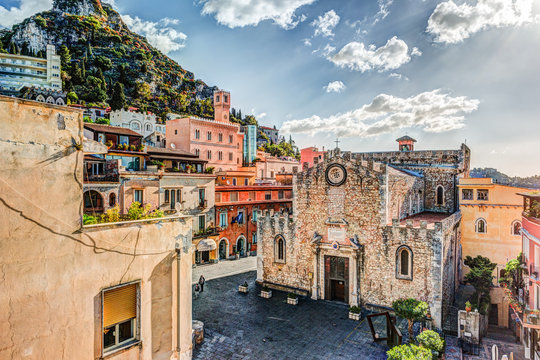 The Duomo in most popular sicilian resort Taormina. Aerial view. Townscape of Taormina with cathedral, square and the hill with other buildings.