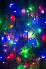 Christmas tree on wood background surround by light bulbs