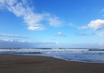 Fototapeta na wymiar Deserted beach near the blue sea