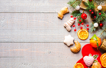 Christmas holiday background with ornaments like cookies and oranges on rustic wooden background.