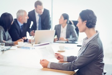 Side view of businesswoman reading report