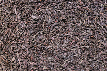 Dried black tea leaves background, texture