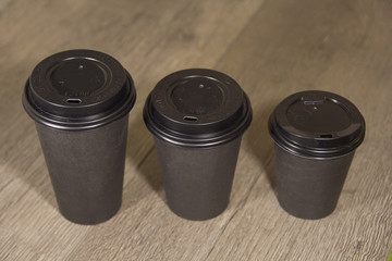 three paper Cup of black coffee on wooden background
