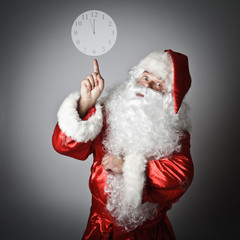 Santa Claus is pointing at the clock