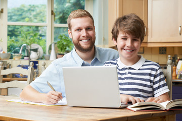 Fototapeta premium Male Home Tutor Helping Boy With Studies