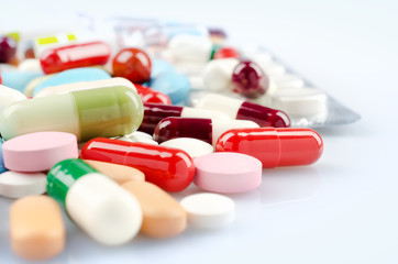 Pharmacy theme. Multicolored Isolated Pills and Capsules on the White Surface. Closeup