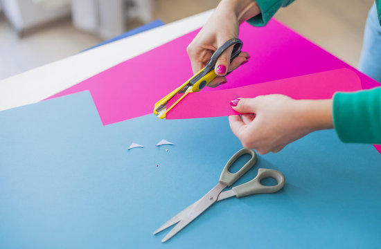 Young woman make scrapbook of the papers on the table using antique tools for cutting paper. Hand made photo album.Shallow depth of field