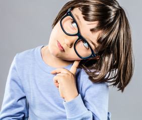 smart young child with serious eyeglasses holding head for intelligence