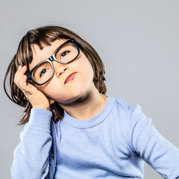 serious preschooler with eyeglasses for thought, imagination, confusion or headache