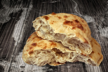 Pitta Bread Loaf Torn In Half Set On Old Weathered Cracked Flaky Wooden Garden Table