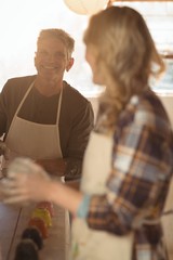 Potters interacting while making working in pottery workshop