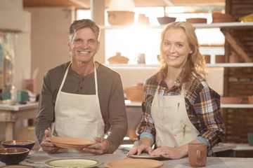 Smiling potters working together in pottery workshop