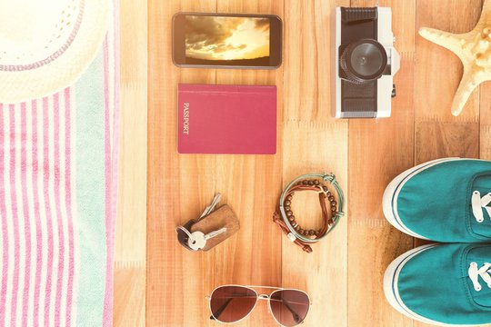 Composite image of accessories and travel items on wooden board