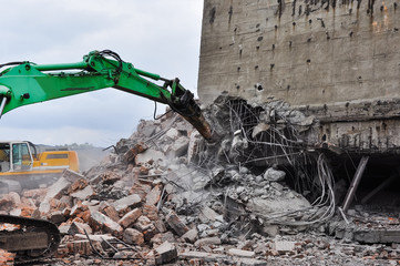 Excavator working at the demolition of an old industrial buildin