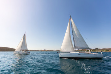 Luxury yachts at regatta. Sailing in the wind through the waves at the Aegean Sea.