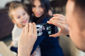 family, parenthood, technology, people concept - happy father taking photo of his little daughter...