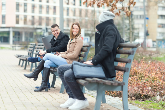 Young people are spending their break on park benches in a downtown district and talking