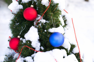 Christmas tree with snow and christmas balls outdoors