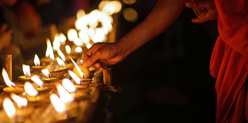Mains de moine bouddhiste tenant une tasse de bougie dans le noir, Chiang Mai, Thaïlande