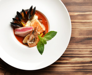 Bowl of fresh seafood soup tom yam with shrimps tuna salmon cala