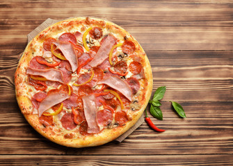Hot big whole tasty pizza with melting cheese bacon tomatoes ham
