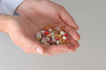 Hand of doctors holding many different pills