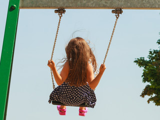 Girl swinging on swing-set.