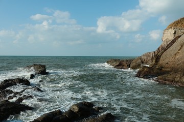 Fototapeta na wymiar 海岸/打ち寄せる波が激しい岩場の海岸
