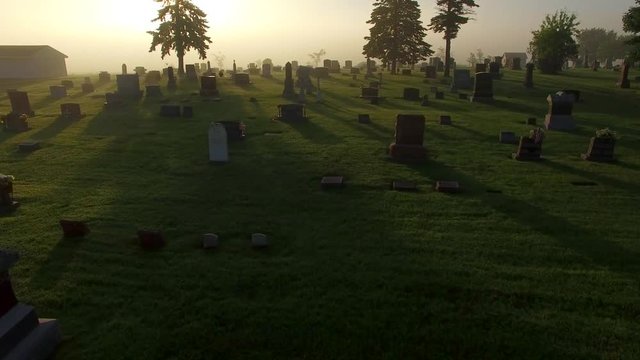 Cemetery on foggy morning, spectacular low aerial flyover.
