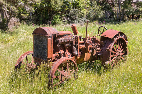 closeup of old rusty tractor in grass field