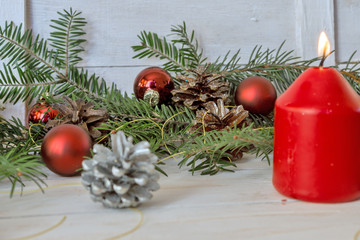 Christmas decoration with fir branches, cones and toys on white wooden background