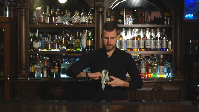 bartender is wiping a glass