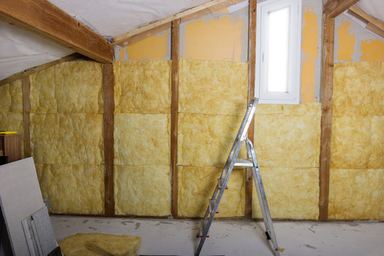 termal insulation installing at the attic with metallic ladder