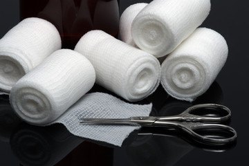 Medical bandage with scissors on black background