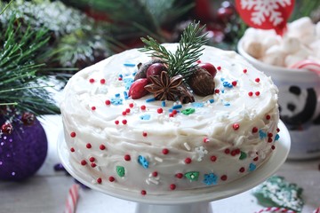 Homemade White Christmas cake with vanilla frosting and holiday sprinkles, selective focus