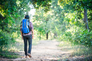 Obraz premium Young hipster man walking on the rural road during hikes on vaca