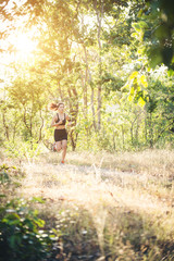 Young woman jogging on rural road in forest nature.