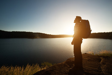 Silhouette of hiker man with backpack in beautiful sunset summer