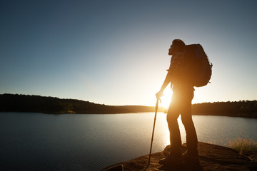 Silhouette of hiker man with backpack in beautiful sunset summer